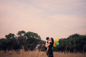 how to mindfully manage a tantrum: Mother in a field holds her baby and some balloons