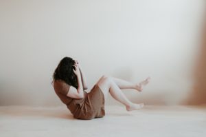 What is the best meditation for anxiety: Woman in brown dress holds her face in her hands
